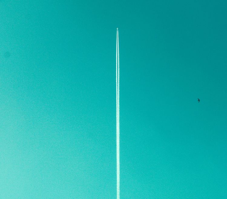 Photo by Miti / Unsplash - Airplane with contrail